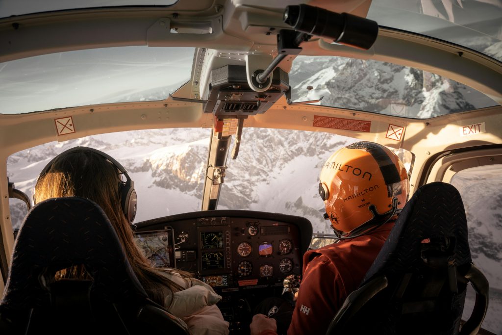 Explore the stunning snowcapped peaks of the Swiss Alps from a helicopter cockpit. Adventure awaits.